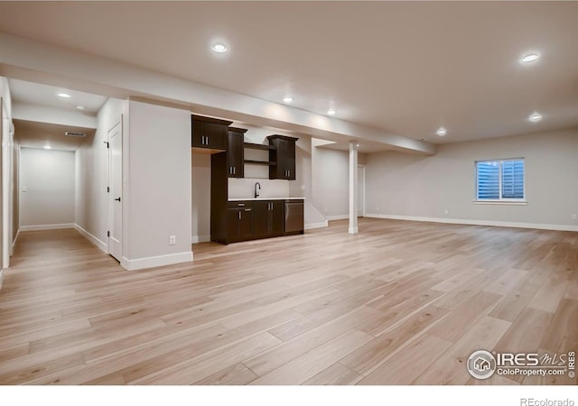 unfurnished living room featuring light wood-type flooring and sink