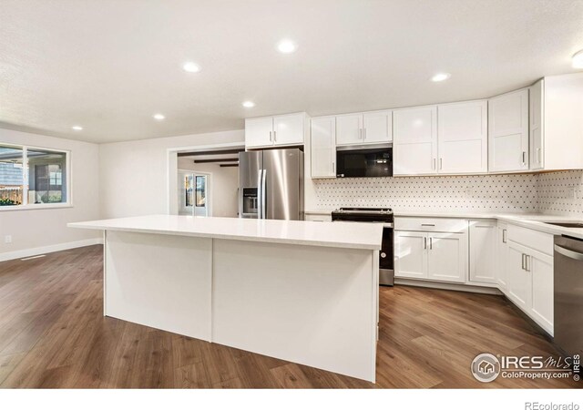 kitchen featuring white cabinetry, a center island, dark wood-type flooring, and stainless steel appliances