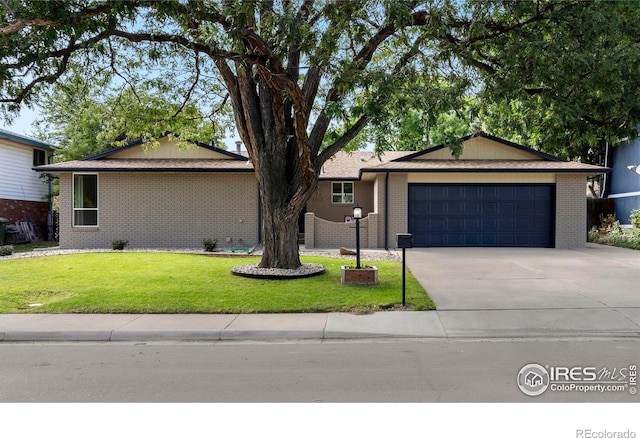 ranch-style home featuring a garage and a front lawn