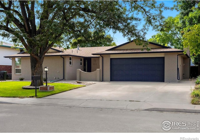 single story home featuring a front lawn and a garage