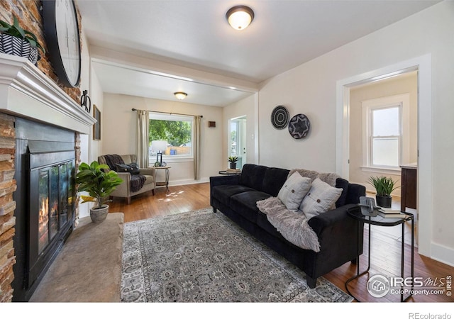 living room featuring a stone fireplace and hardwood / wood-style flooring