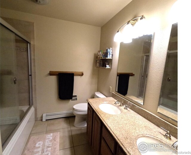 bathroom with tile patterned flooring, toilet, a sink, and baseboard heating