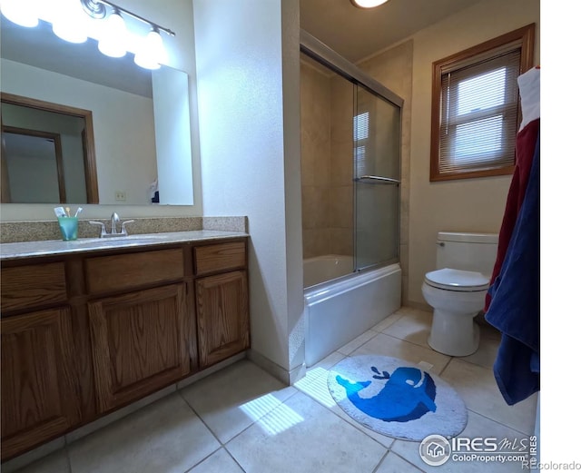 bathroom with toilet, vanity, enclosed tub / shower combo, and tile patterned floors