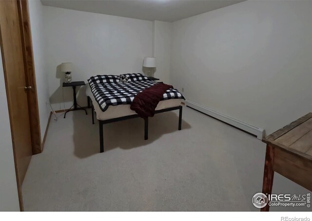 bedroom featuring a baseboard heating unit and carpet flooring