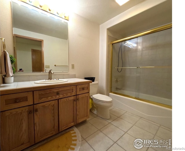 full bathroom featuring toilet, vanity, bath / shower combo with glass door, and tile patterned floors