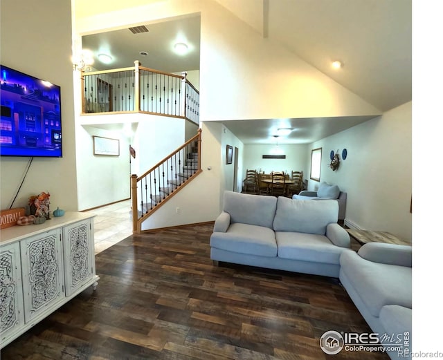 living area with high vaulted ceiling, stairway, wood finished floors, and visible vents