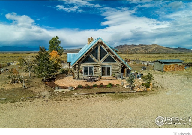 log home with a mountain view, a rural view, and a storage shed