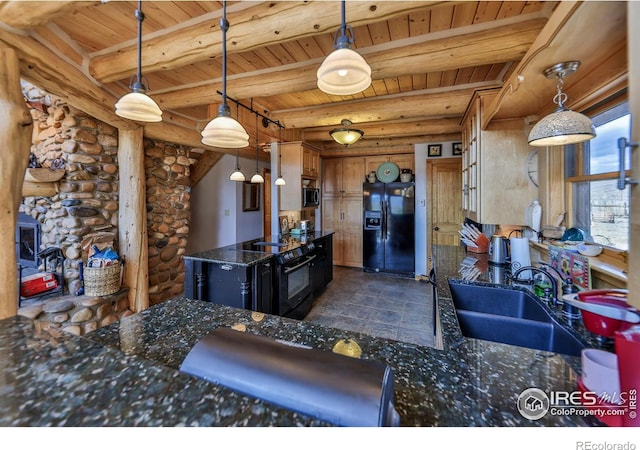 kitchen with pendant lighting, dark stone countertops, black appliances, and sink