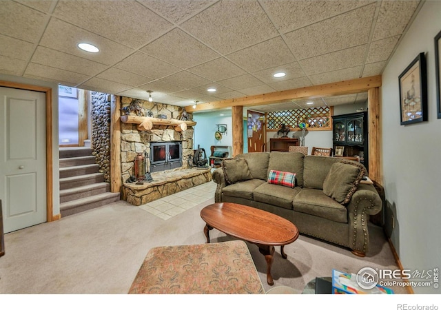 living room featuring carpet floors, a paneled ceiling, and a fireplace