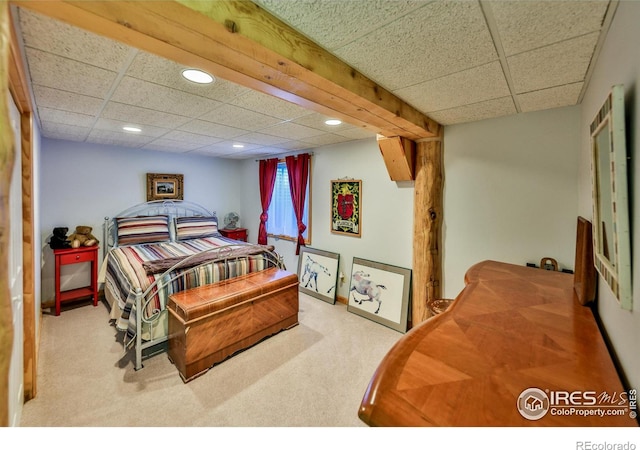 bedroom featuring a drop ceiling and light colored carpet