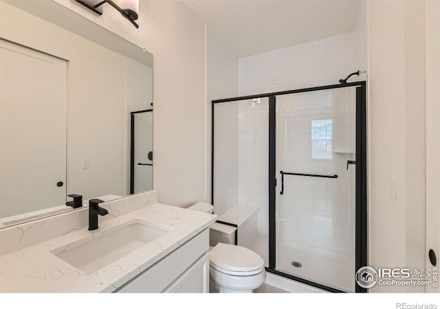 bathroom with vanity, an enclosed shower, and toilet