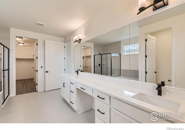 bathroom with tile patterned floors, vanity, and a shower with shower door