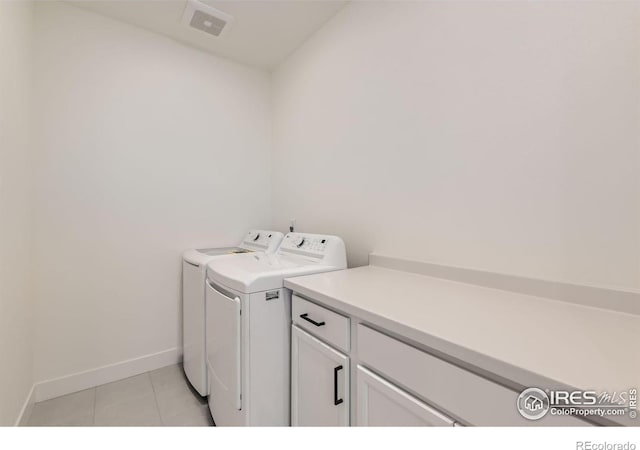 laundry room featuring light tile patterned floors, cabinets, and independent washer and dryer