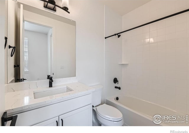 full bathroom with toilet, vanity, and tiled shower / bath