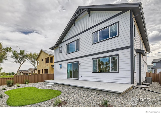 rear view of house with cooling unit and a patio