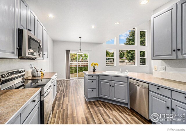 kitchen featuring sink, hanging light fixtures, gray cabinets, and stainless steel appliances