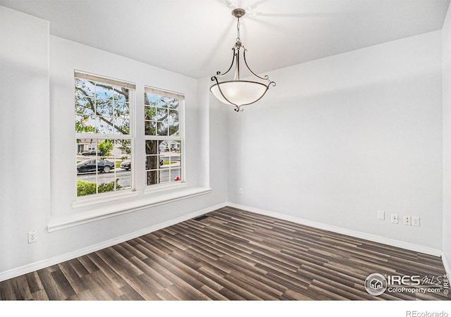 unfurnished dining area featuring dark wood-type flooring