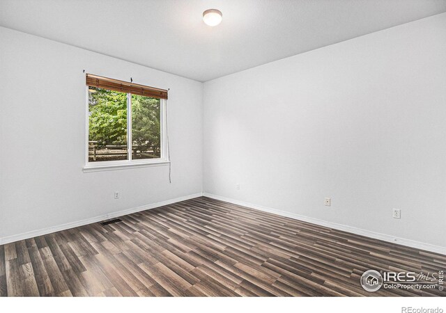 empty room featuring dark hardwood / wood-style flooring