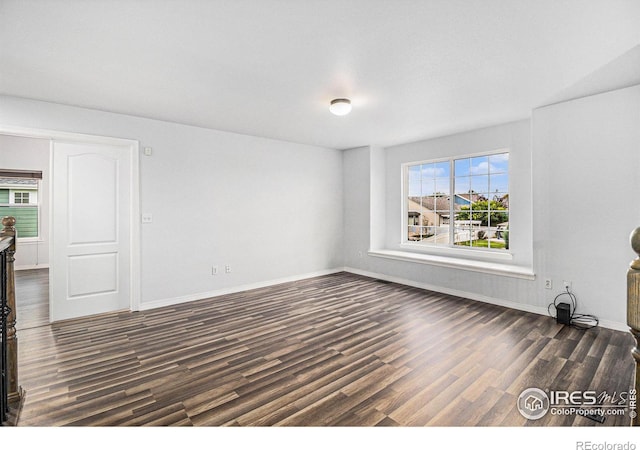 unfurnished living room featuring plenty of natural light and dark wood-type flooring