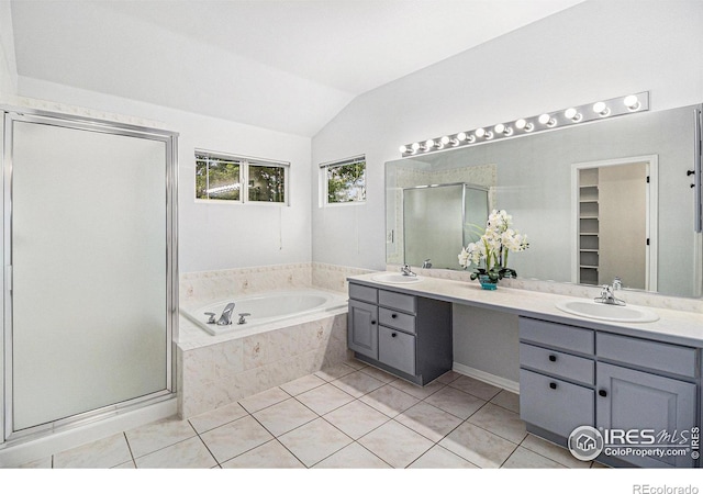 bathroom featuring vanity, vaulted ceiling, independent shower and bath, and tile patterned floors