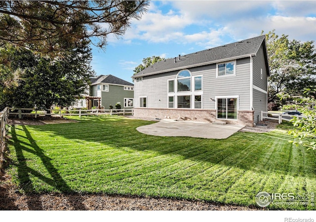 rear view of property featuring a yard and a patio