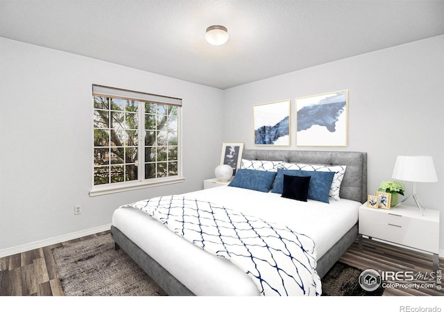 bedroom with dark hardwood / wood-style flooring