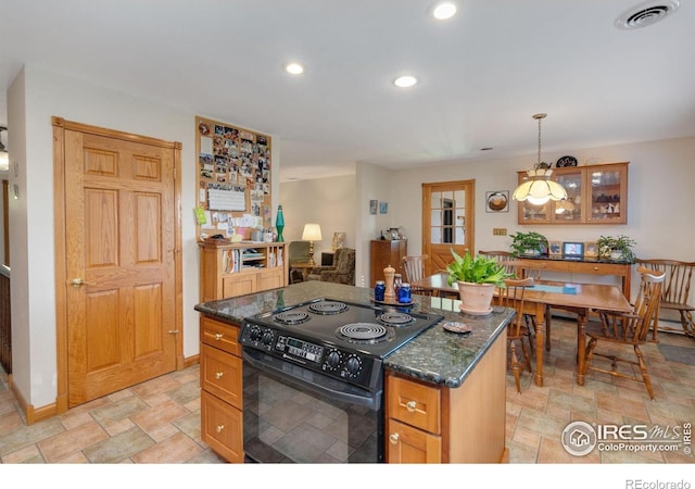 kitchen with dark stone countertops, decorative light fixtures, black range with electric cooktop, and a kitchen island