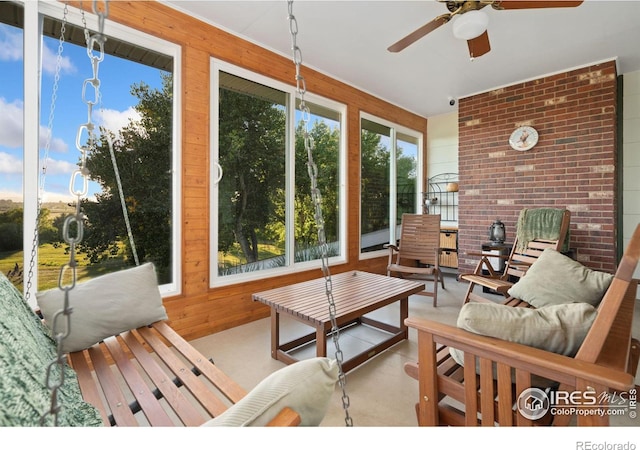 interior space featuring ceiling fan, wood walls, and concrete floors