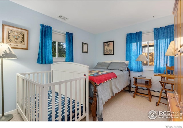 bedroom featuring a baseboard radiator, multiple windows, and carpet flooring