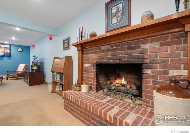 living room with a brick fireplace, carpet floors, and beam ceiling