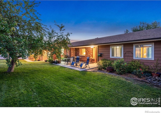 rear view of house with a patio area and a lawn