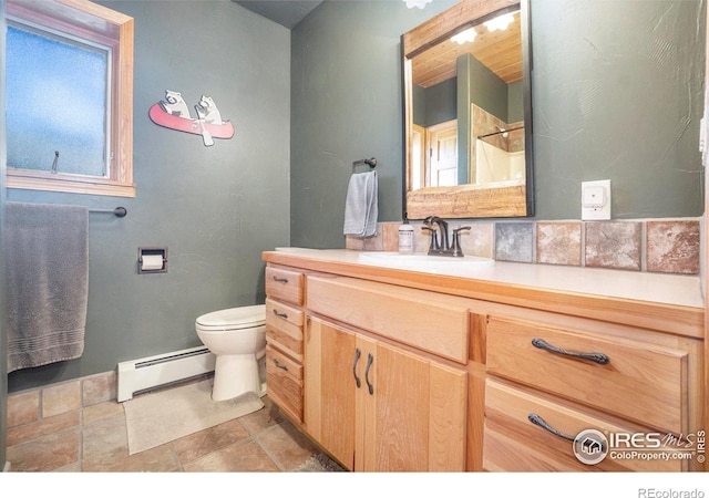 bathroom with vanity, toilet, and a baseboard heating unit