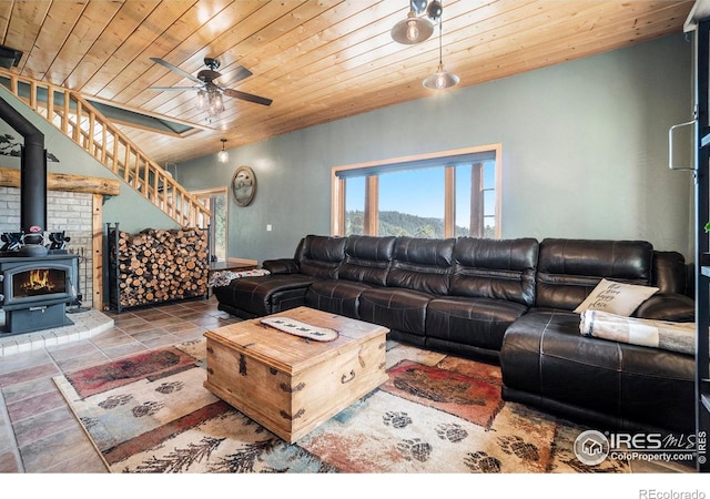 living room with a wood stove, ceiling fan, and wood ceiling