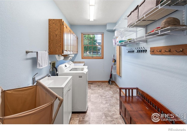 washroom featuring cabinets, washer and dryer, and a textured ceiling