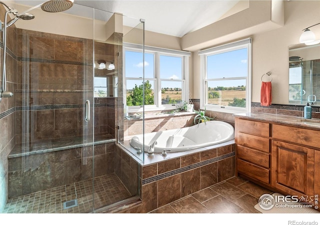 bathroom featuring shower with separate bathtub, lofted ceiling, and vanity