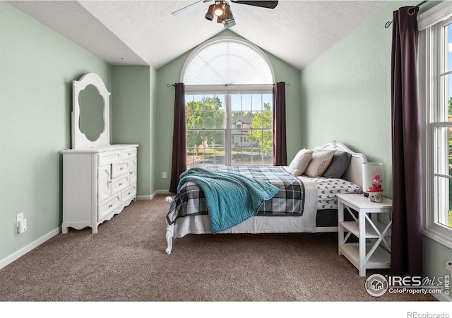 bedroom with ceiling fan, vaulted ceiling, a textured ceiling, and carpet