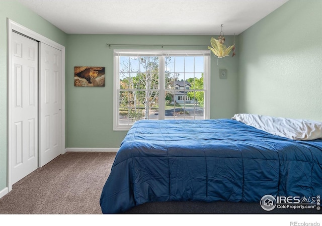 carpeted bedroom featuring a closet and a textured ceiling