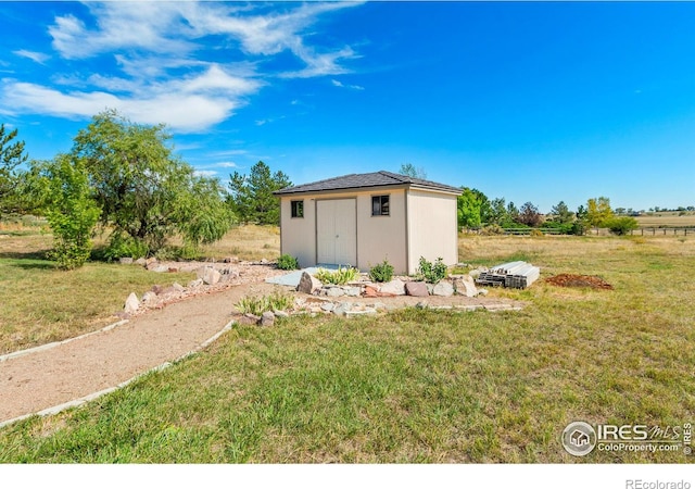 view of outbuilding with a rural view and a lawn