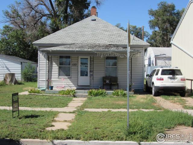 bungalow-style home with a porch and a front lawn