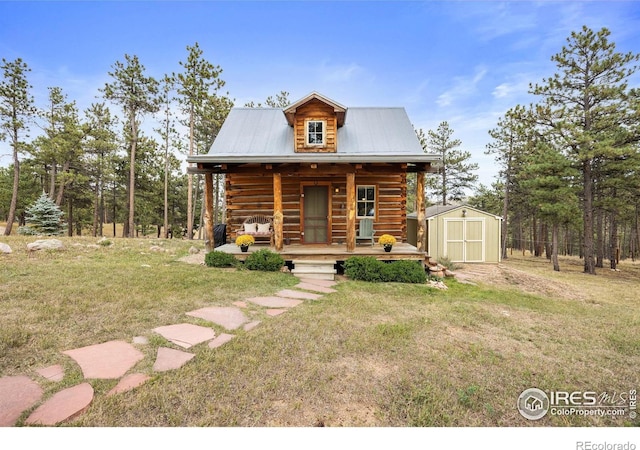 log-style house with covered porch, a shed, and a front yard