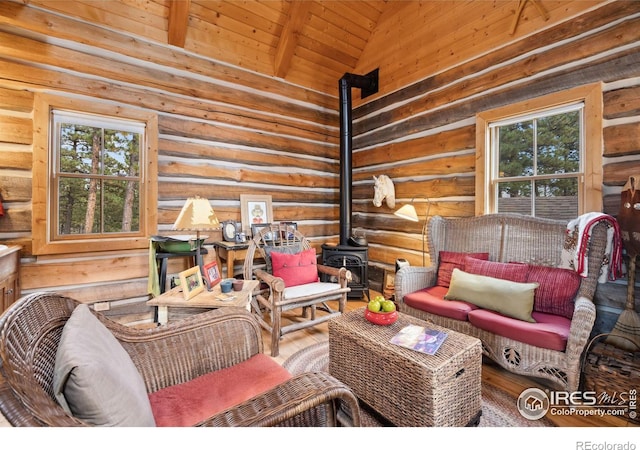 living room with rustic walls, wood ceiling, beam ceiling, high vaulted ceiling, and a wood stove