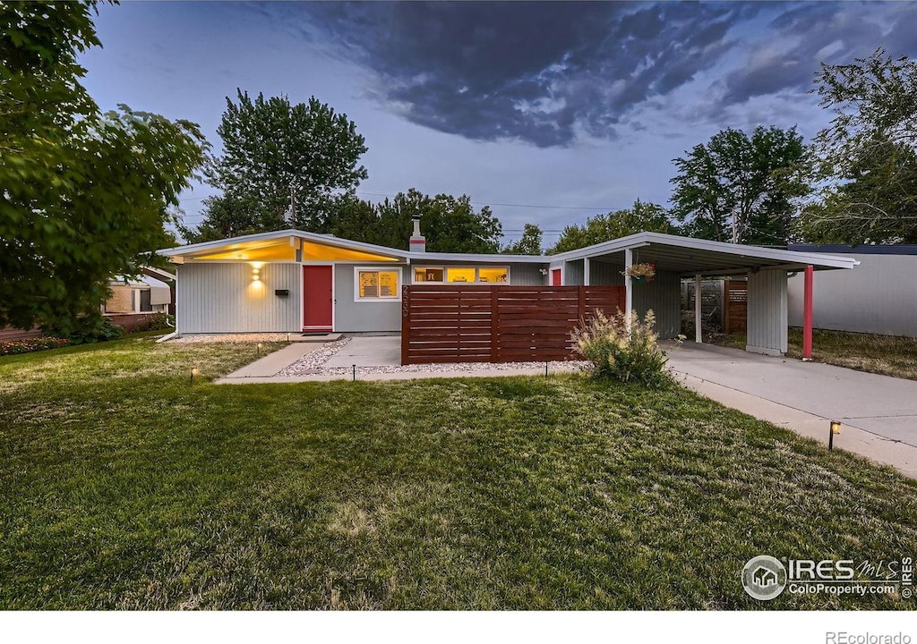 ranch-style house featuring a front lawn and a carport