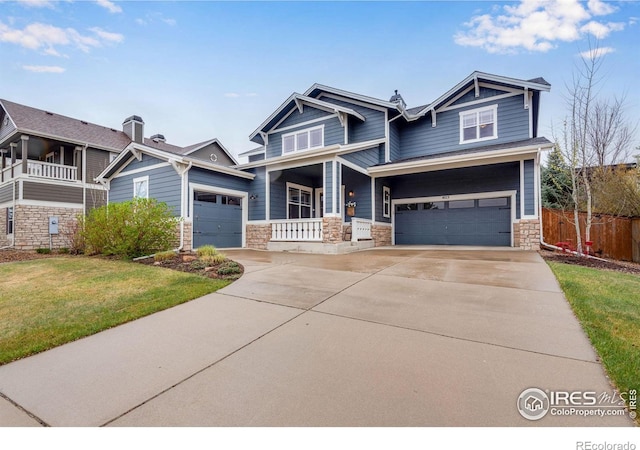 craftsman inspired home featuring a balcony, covered porch, a front yard, and a garage