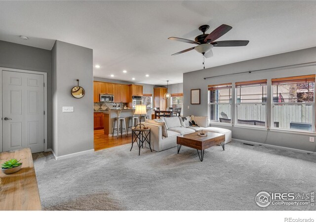 carpeted living room featuring ceiling fan