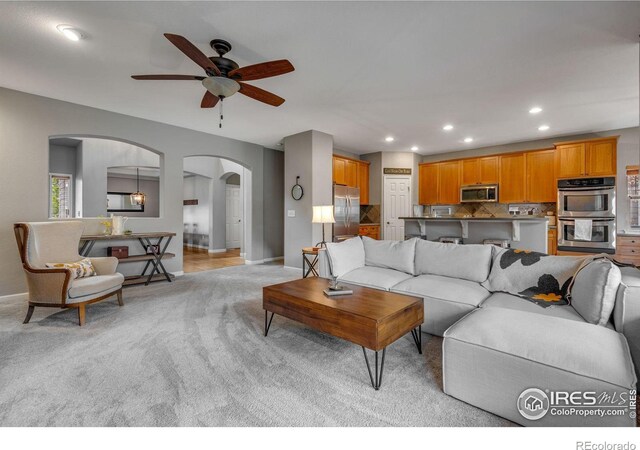 living room featuring light carpet and ceiling fan