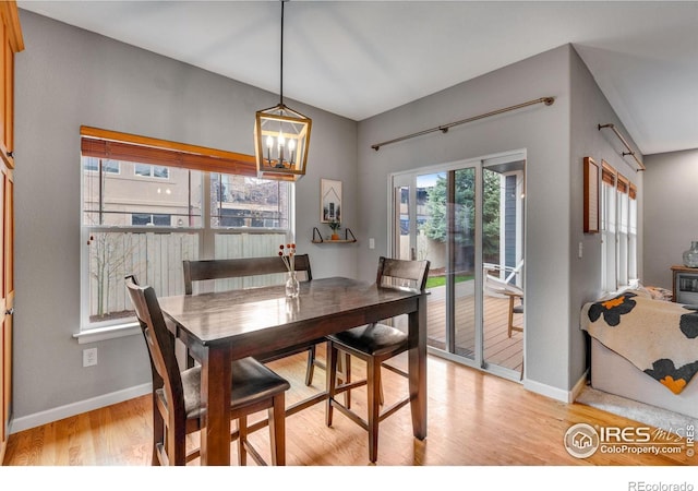 dining room featuring light wood-type flooring, a chandelier, and plenty of natural light