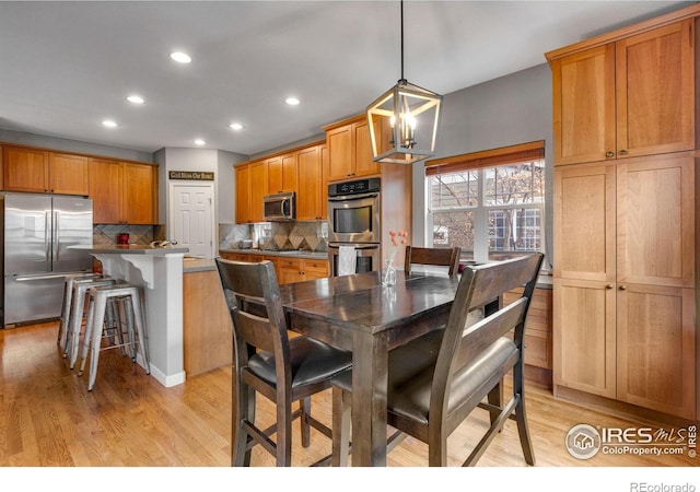 dining room featuring light wood-type flooring and a chandelier