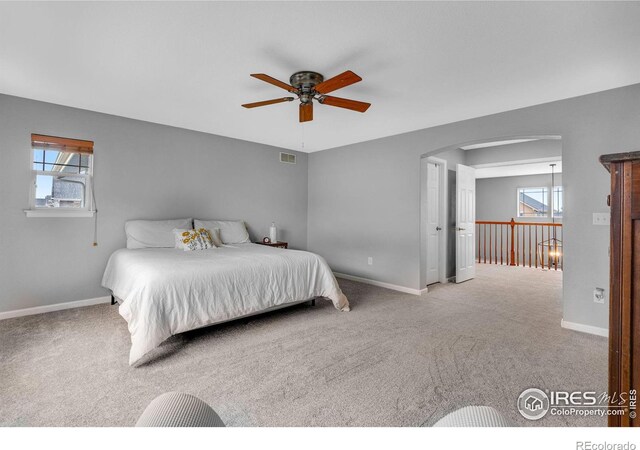 carpeted bedroom with multiple windows and ceiling fan