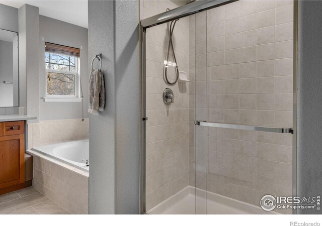 bathroom with plus walk in shower, tile patterned floors, and vanity