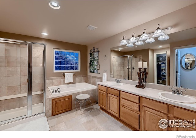 bathroom featuring tile patterned flooring, vanity, and shower with separate bathtub